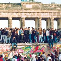 Germans from East and West stand on the Berlin Wall in front of the Brandenburg Gate in the November 10, 1989, photo, one day after the wall opened.