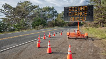 Roadside sign and orange cones; the sign reads &quot;Second Chance Ahead&quot;