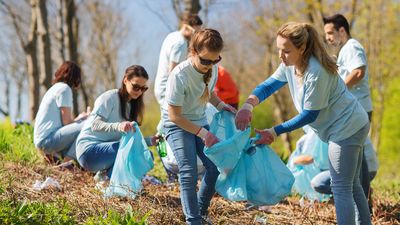 Community service - volunteers picking up garbage in a park during a spring cleanup. Environmentalism